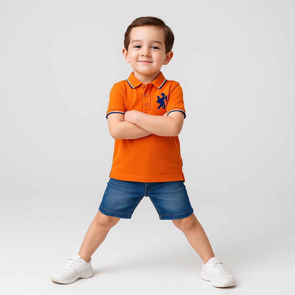 Child wearing an orange polo shirt with a logo and blue shorts on a light gray background